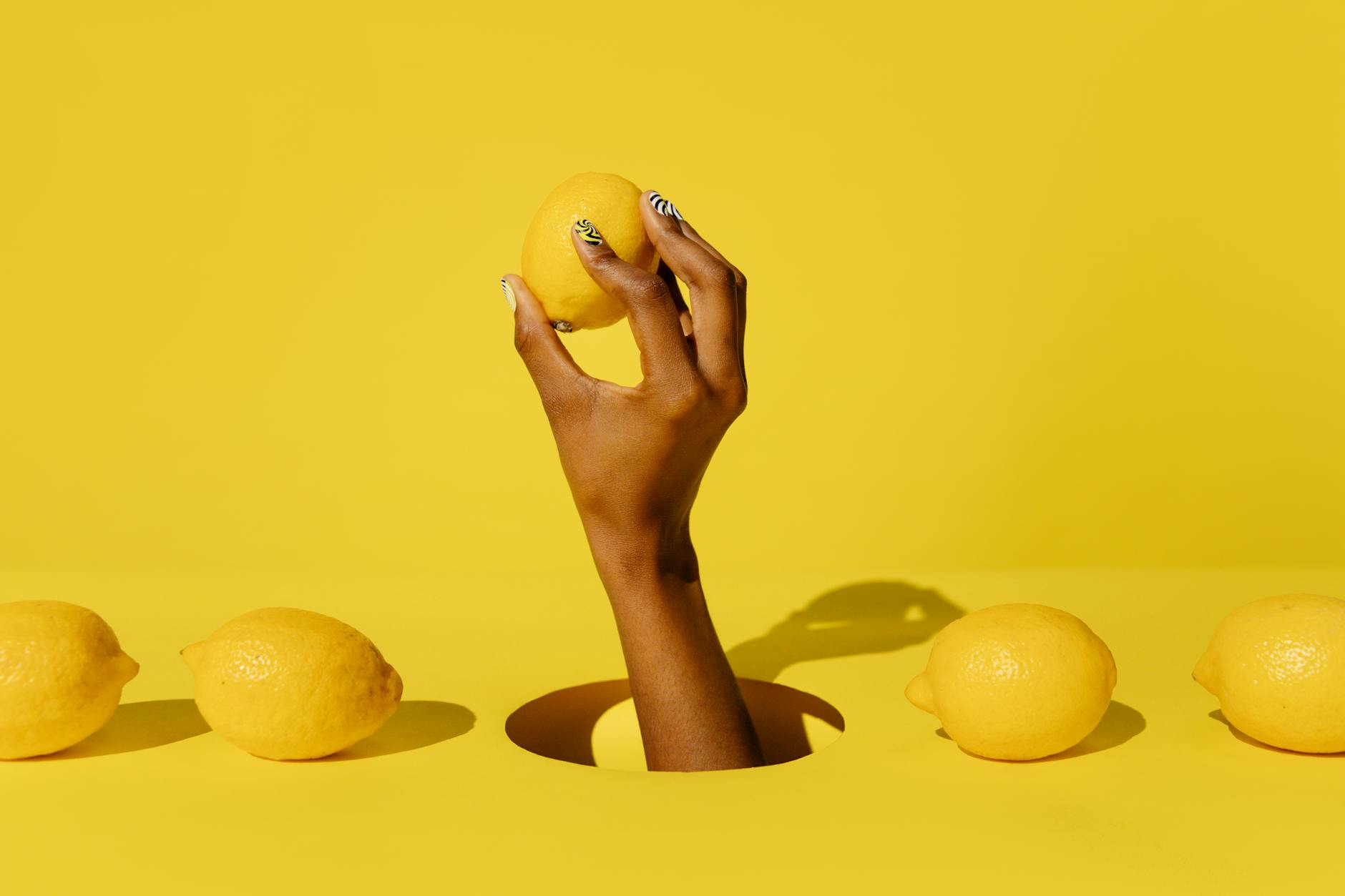Two hands cupping fresh lemons on a brown surface, symbolizing touch and connection