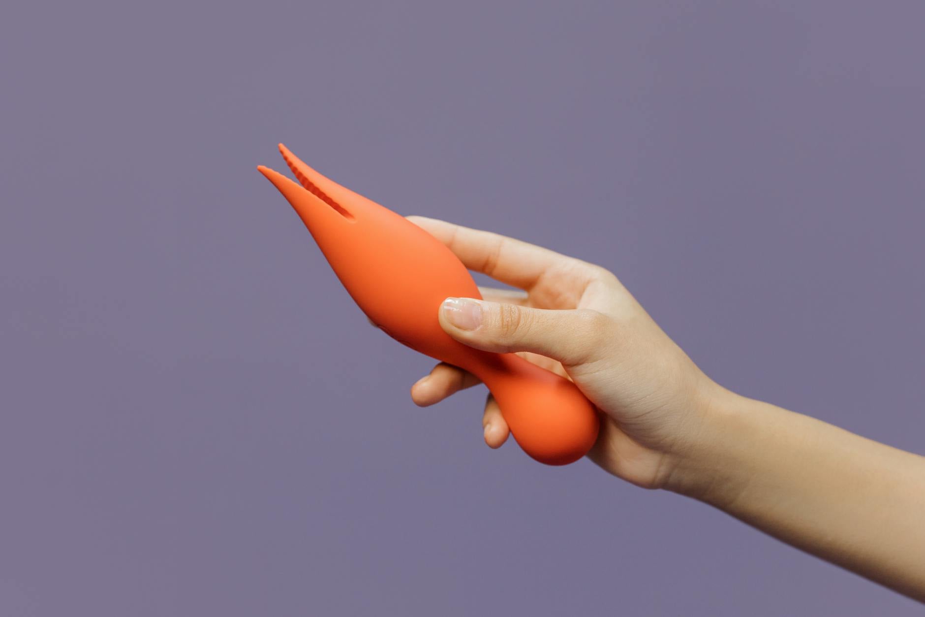 Hand holding a fresh lemon on soft pink background, symbolizing the delicate balance of perimenopause and pleasure