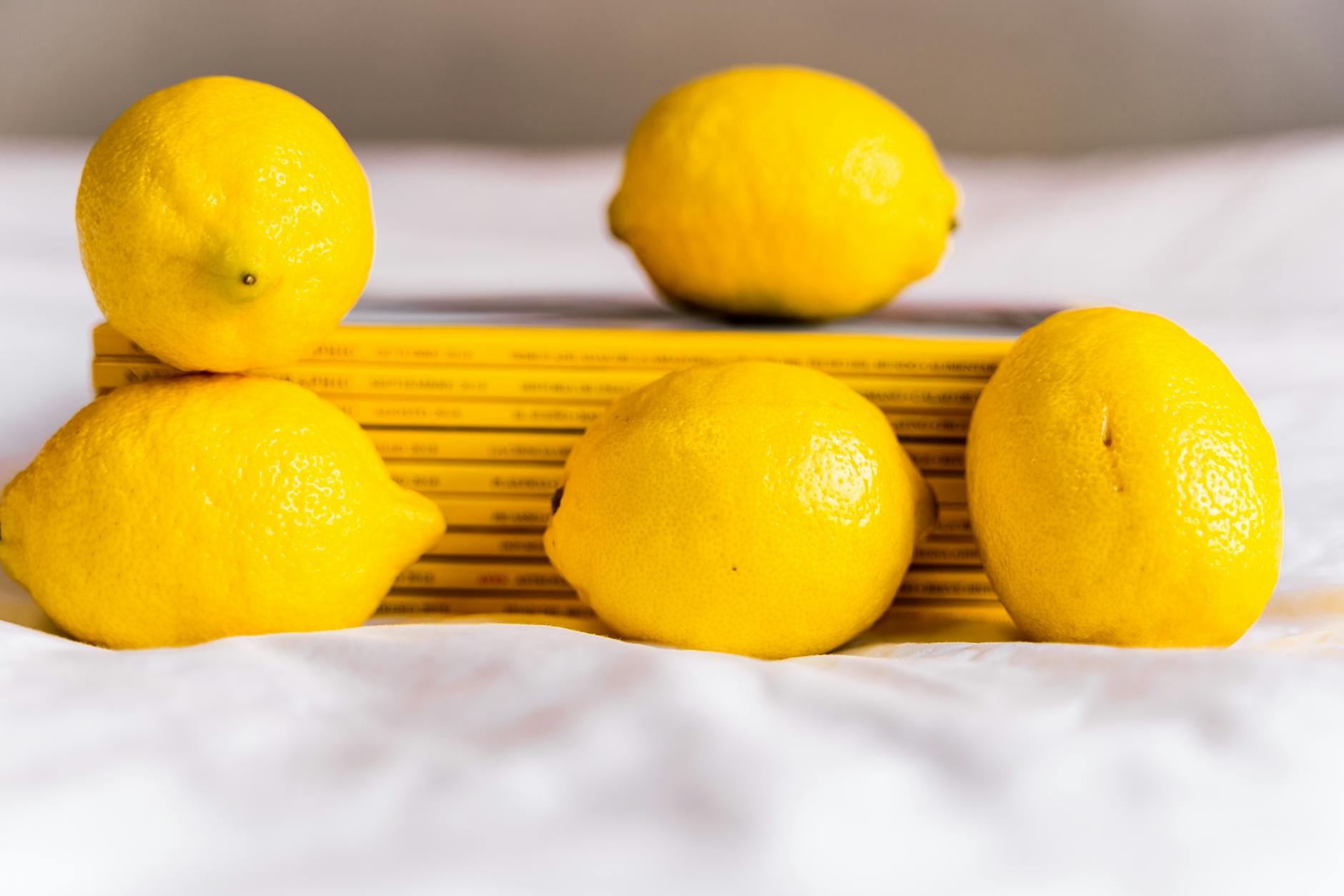 Bright yellow lemons arranged on a soft pastel green background, evoking calm and gentle renewal